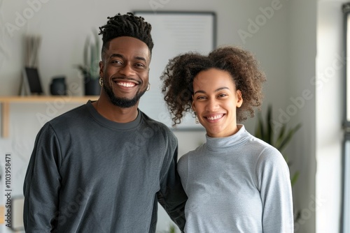 Portrait of a satisfied multiethnic couple in their 30s showing off a lightweight base layer in front of stylized simple home office background photo