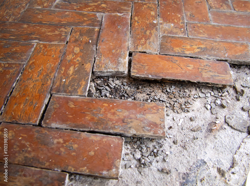 Old crumbling parquet floor covering on concrete floor