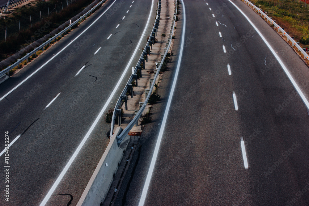 Aerial view of a paved highway road with white markings seen from above. Road repair, travel concept. Separating lanes on the road, a baffle for the safe movement of cars. Aerial view of a paved highway road with white markings seen from above. Road repair, travel concept. Separating lanes on the road, a baffle for the safe movement of cars.