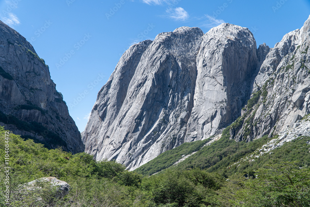 Stunning view from the Cochamó Valley trek in Southern Chile, showcasing lush green landscapes, towering granite cliffs, and pristine natural beauty on a clear day.