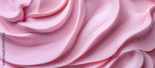 A close-up view of smooth, swirled pink frosting or cream.