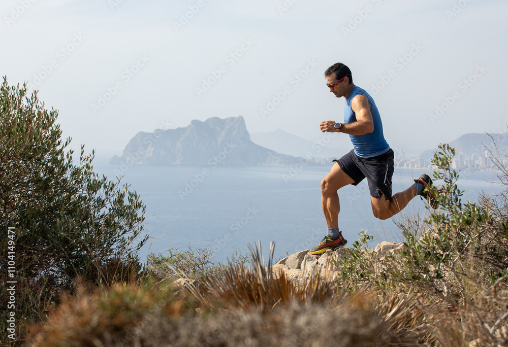 Man trail running on rocky path with scenic ocean view Man trail running on rocky path with scenic ocean view