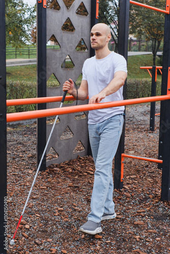 Blind man with visual disability navigating outdoor obstacle course photo