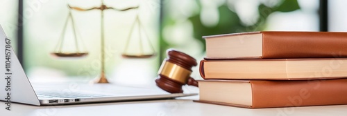 Gavel and books near laptop with justice scales behind