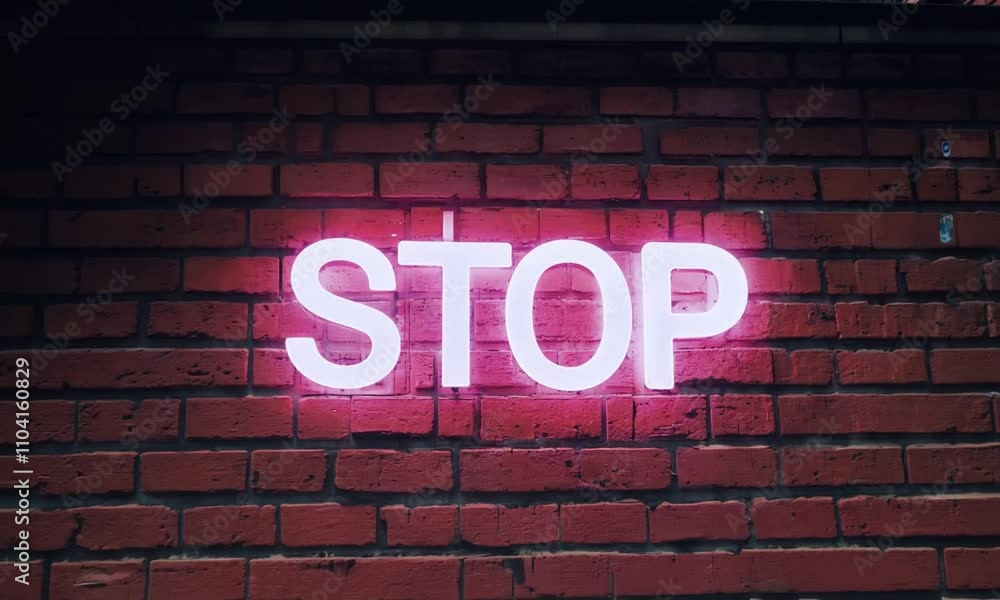 Flashing neon sign displaying the word stop against a brick wall Flashing neon sign displaying the word stop against a brick wall