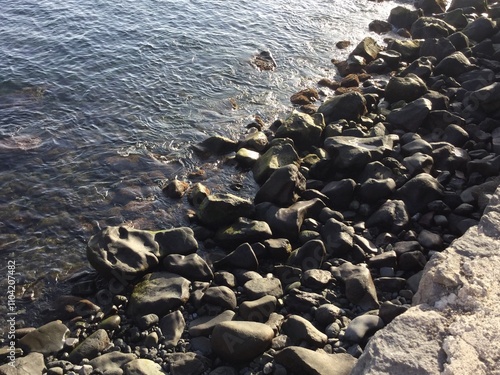 Rocky shoreline at sunset near the water photo