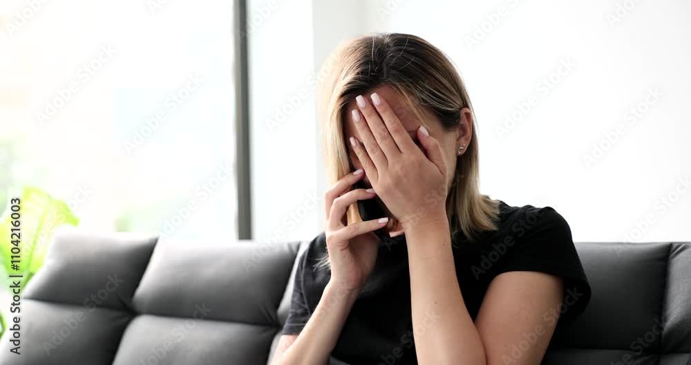 Woman makes face palm gesture talking on mobile phone at home. Female expresses frustration revealing absurd detail during conversation Woman makes face palm gesture talking on mobile phone at home. Female expresses frustration revealing absurd detail during conversation