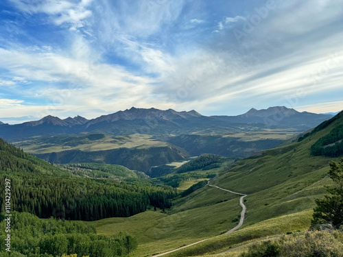 Last dollar hut mountain view above Telluride Colorado with gravel road in foreground and cloudscape over the mountains