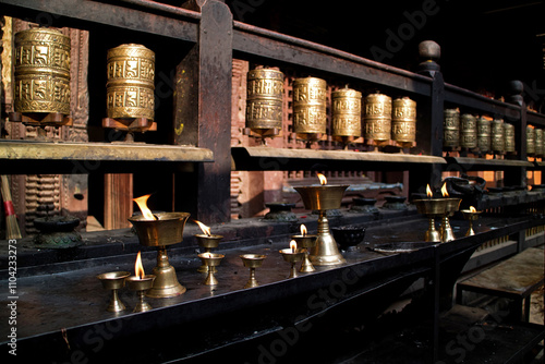 Prayer wheels and butter lamps in a monastry in Kathmandu, Nepal photo