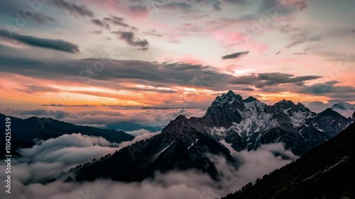 The sun slowly rises over the misty mountain