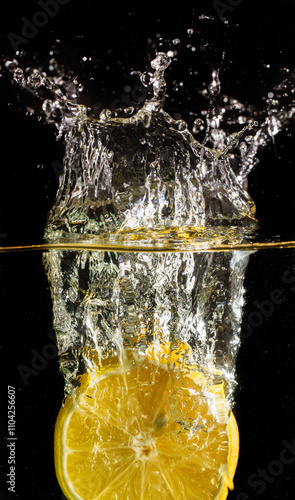 Ripe yellow lemon falling into water vertically. Frozen splash on dark background