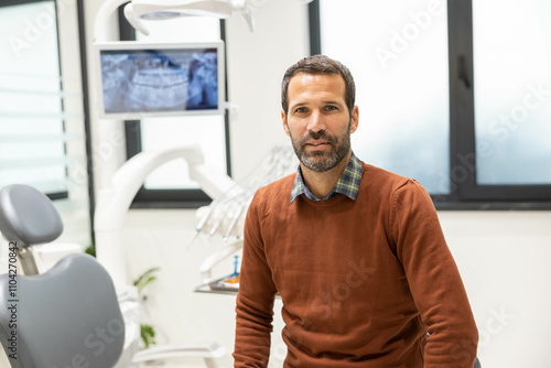 A man sits ready for a dental appointment, surrounded by up-to-date dental care tools and equipment, projecting calmness and composure in the dental setting.