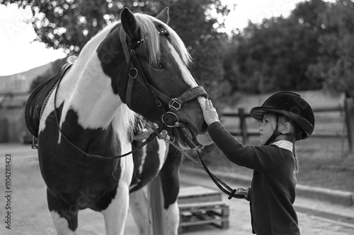 Young girl riding a horse in a traditional stable, embodying the classic bond between rider and steed photo