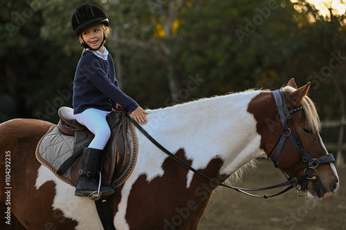 Принти на полотні Young girl riding a horse in a traditional stable, embodying the classic bond be