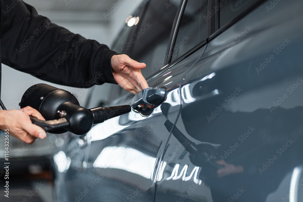 Professional Man Washes Car and Dries with Tool from Drops at Car Wash. Auto Detailing Professional Man Washes Car and Dries with Tool from Drops at Car Wash. Auto Detailing