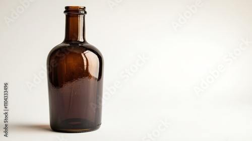  a brown glass bottle sitting on top of a white surface The bottle has a cylindrical shape with a wide mouth and a narrow neck The glass is transparent, allowing t