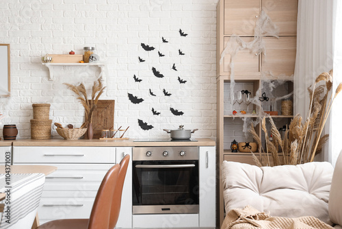 Interior of kitchen decorated for Halloween with white counters and shelf unit photo