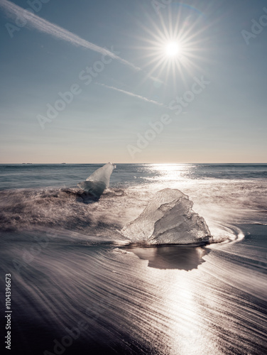 Long exposure image of broken off glacier ice washed up on shore of black sand Diamond Beach on Iceland