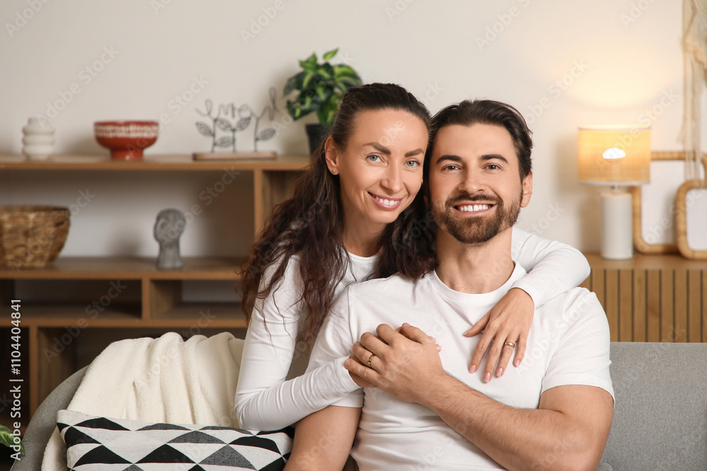 Fototapeta premium Happy wife hugging her husband at home