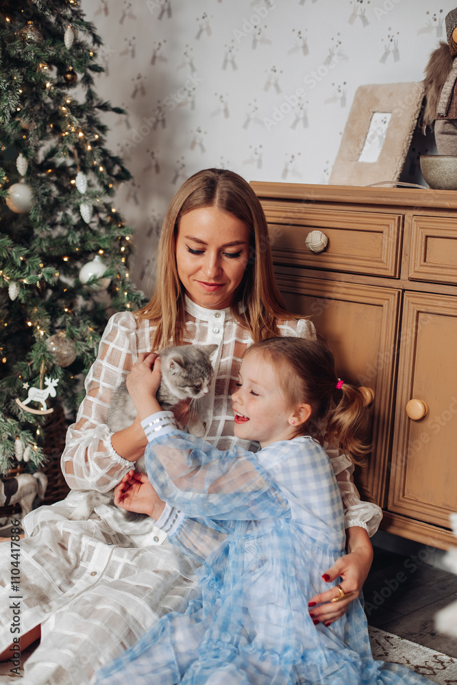Smiling girl with mom near christmas tree at home Smiling girl with mom near christmas tree at home