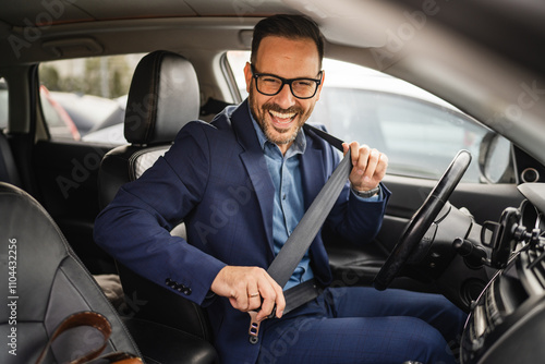 Adult businessman sit in the car and go to work and put his seat belt