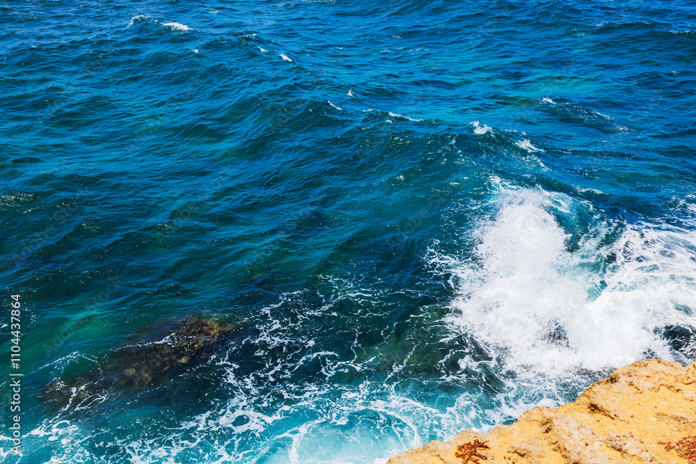 Close-up view of waves crashing against rocky coastline in Arikok National Park, Aruba, with vibrant blue water. Close-up view of waves crashing against rocky coastline in Arikok National Park, Aruba, with vibrant blue water.