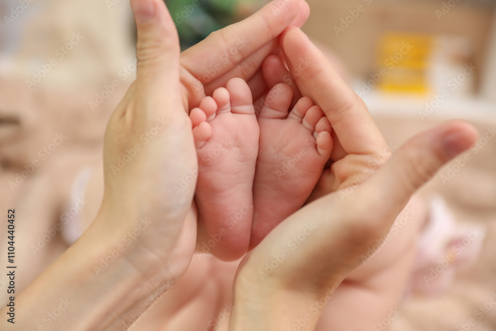Mother's hands holding the feet of a newborn. Maternal care concept Mother's hands holding the feet of a newborn. Maternal care concept