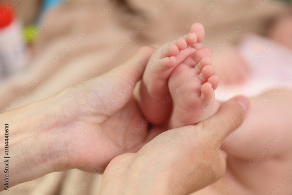 Mother's hands holding the feet of a newborn. Maternal care concept Mother's hands holding the feet of a newborn. Maternal care concept