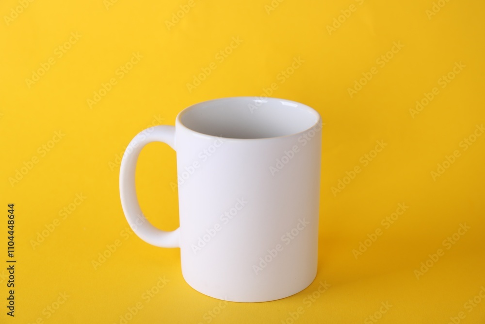 One blank white mug on yellow background. Mockup for design One blank white mug on yellow background. Mockup for design