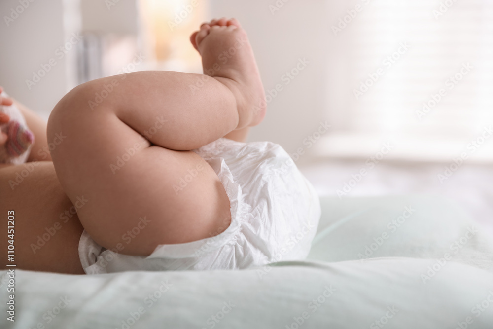 Obraz premium Cute little baby in diaper on bed indoors, closeup. Space for text