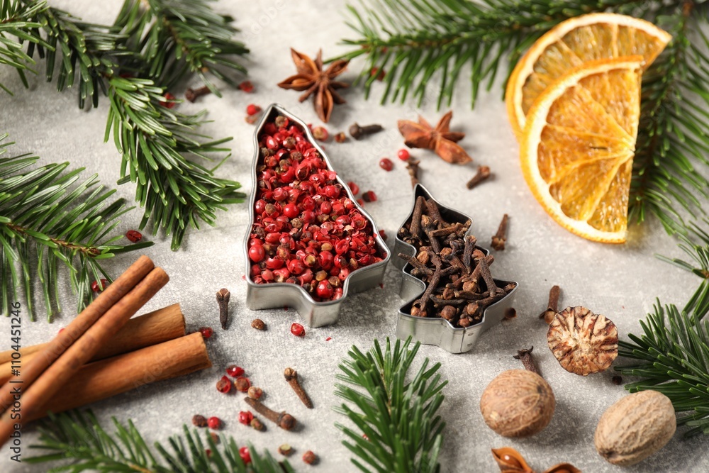 Different spices, dried orange slices and fir tree branches on light grey table. Christmas season Different spices, dried orange slices and fir tree branches on light grey table. Christmas season
