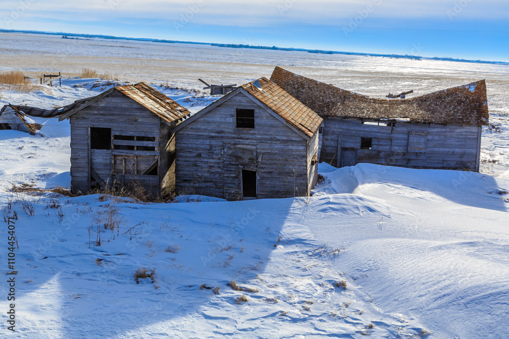 A small, old, wooden house is surrounded by snow A small, old, wooden house is surrounded by snow