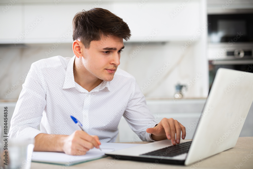 Young man getting knowledge using internet and laptop at home Young man getting knowledge using internet and laptop at home