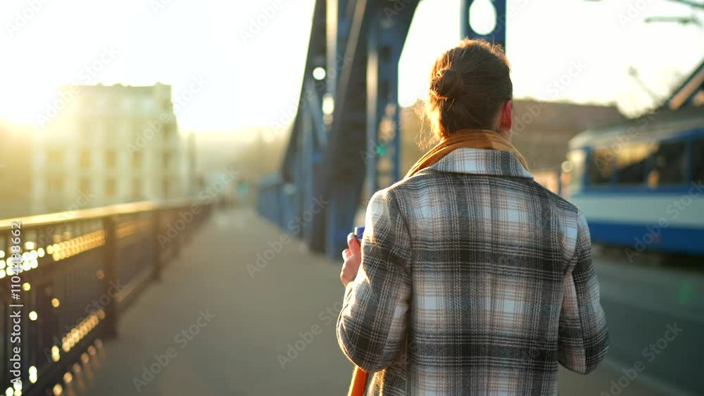 Woman walking in a frosty sunny morning, drinking coffee and using smartphone Woman walking in a frosty sunny morning, drinking coffee and using smartphone