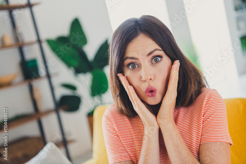 Surprised young woman in a striped t-shirt spending a cheerful day at home