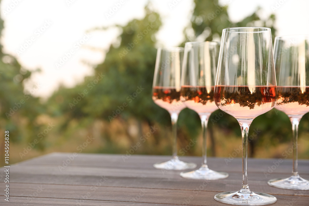 Tasty wine in glasses on wooden table outdoors, closeup. Space for text Tasty wine in glasses on wooden table outdoors, closeup. Space for text
