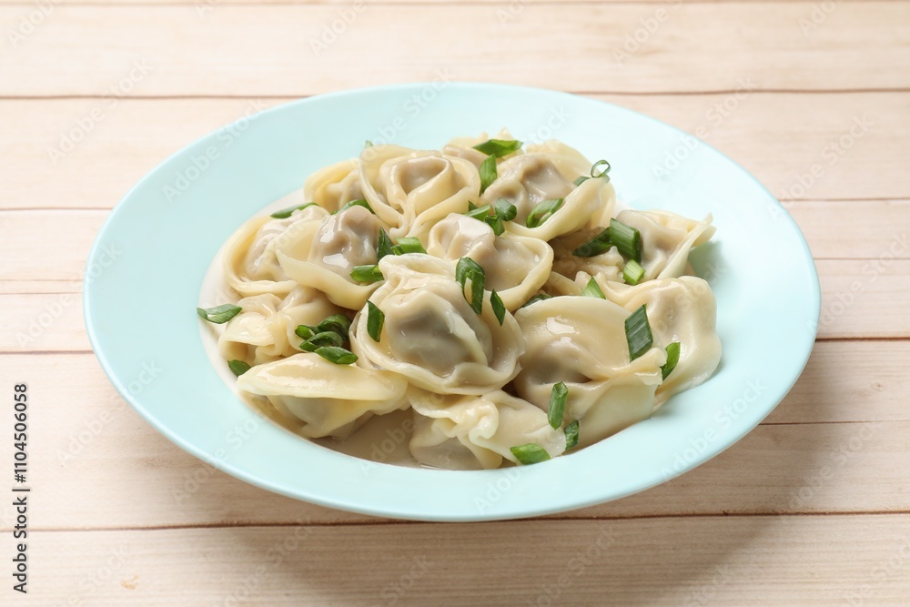 Delicious pelmeni with green onion on white wooden table Delicious pelmeni with green onion on white wooden table