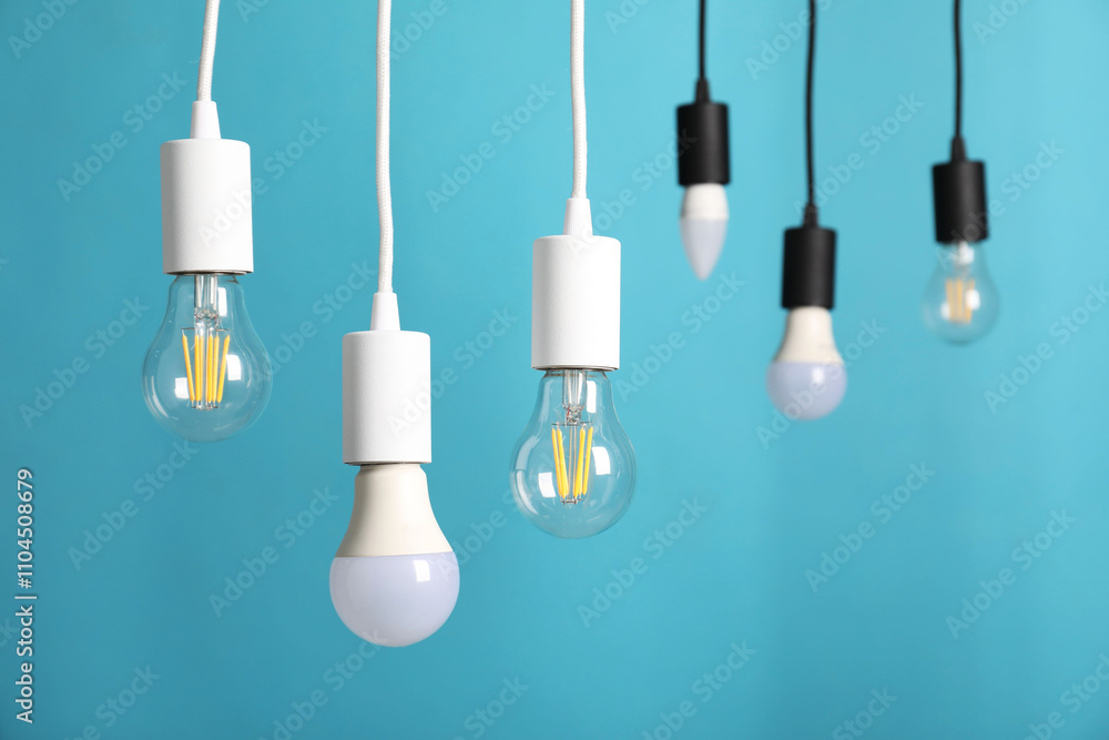 Light bulbs hanging on cords against light blue background Light bulbs hanging on cords against light blue background