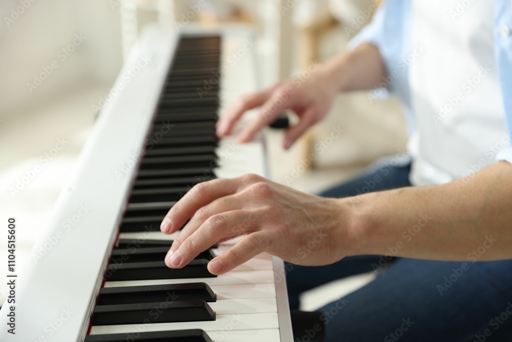 Obraz premium Man playing synthesizer indoors, closeup. Electronic musical instrument