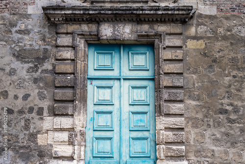 Blue wood old pannelled door in a stone wall photo