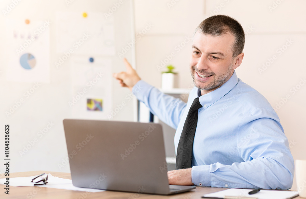 Distant Work. Businessman At Laptop Making Video Call Communicating With Employees Sitting In Modern Office Distant Work. Businessman At Laptop Making Video Call Communicating With Employees Sitting In Modern Office