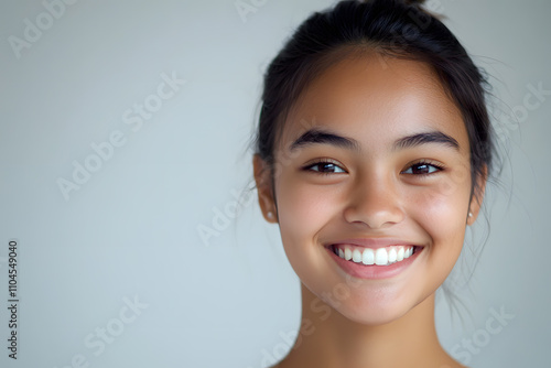 Portrait of smiling Indonesian young adult girl with lively and joyful expression on clean background