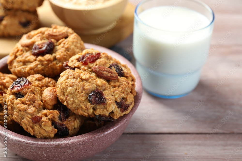 Delicious oatmeal cookies with raisins, nuts and milk on wooden table, closeup Delicious oatmeal cookies with raisins, nuts and milk on wooden table, closeup