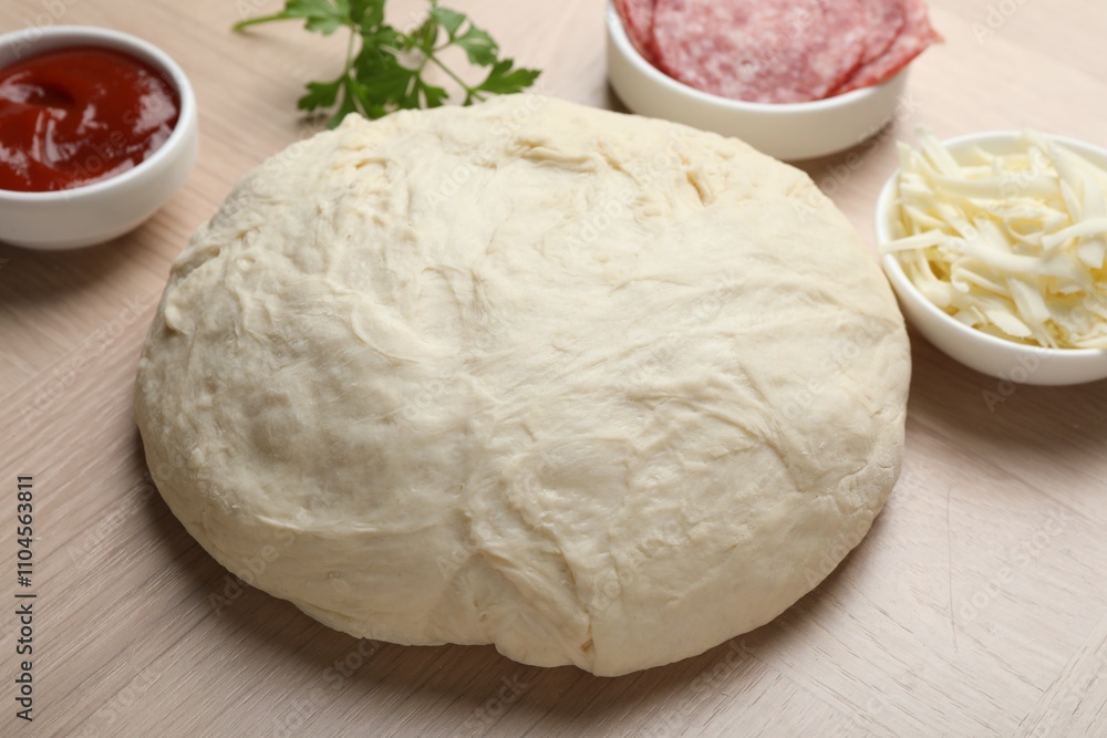 Making calzone pizza. Dough and ingredients on wooden table, closeup Making calzone pizza. Dough and ingredients on wooden table, closeup