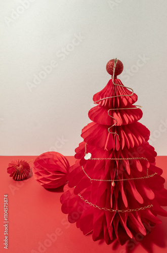 Necklace of golden chane on a red paper Christmas honeycomb tree. photo