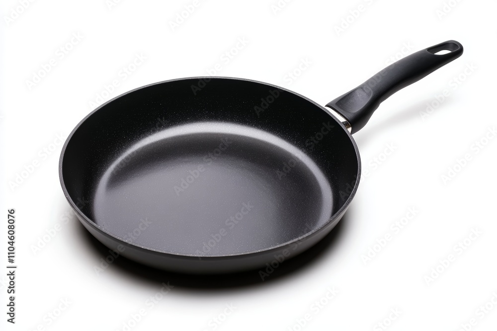 A black pan with a handle sits on a white background A black pan with a handle sits on a white background