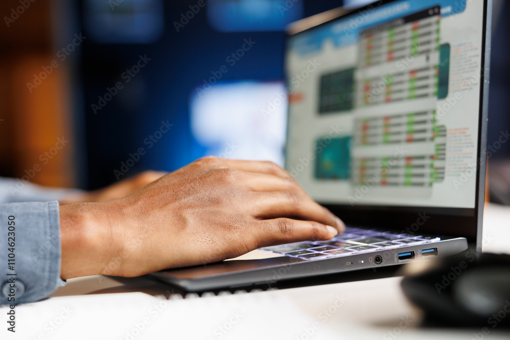 Financial analyst looking into business expenses and profit, trying to create a balance between cost and revenue to help with capital growth. African american man examines economic reports. Close up. Financial analyst looking into business expenses and profit, trying to create a balance between cost and revenue to help with capital growth. African american man examines economic reports. Close up.