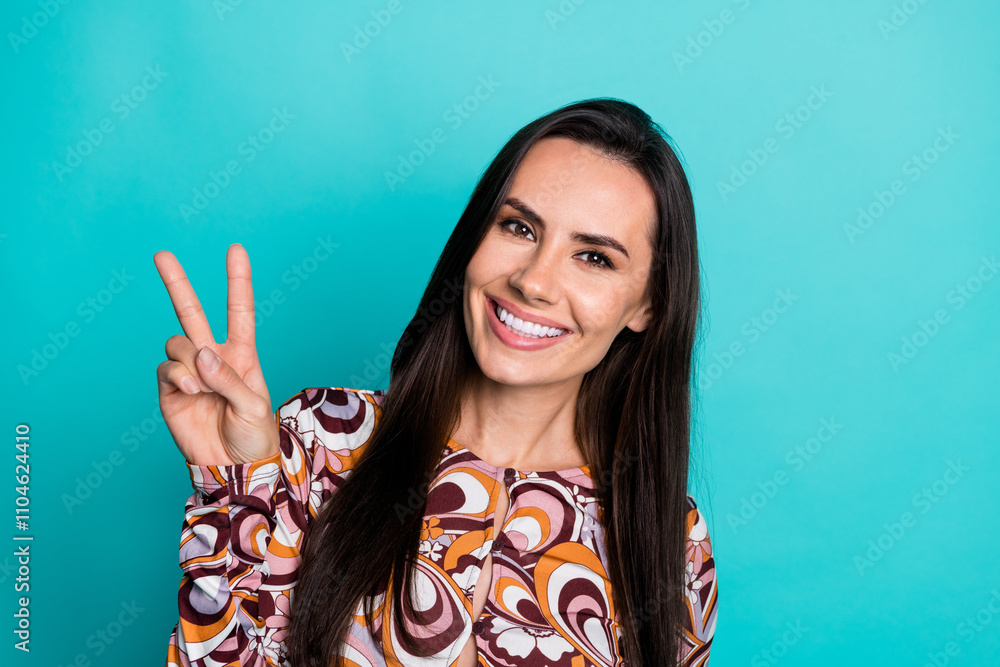 Fototapeta premium Photo of adorable lovely girl wear print shirt showing v-sign empty space isolated turquoise color background