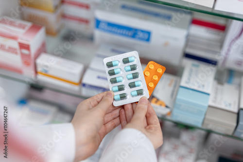 Cuadro en lienzo Hands of pharmacist holding medicine capsule blister pack at shelf stocked in pharmacy drugstore