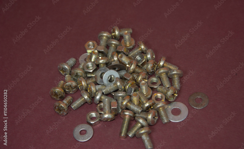 A close-up of a batch of German-style screws with washers and nuts, arranged neatly on a work surface, ideal for construction, industrial, or DIY projects. A close-up of a batch of German-style screws with washers and nuts, arranged neatly on a work surface, ideal for construction, industrial, or DIY projects.